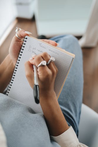 Student Writing Notes on Her Notebook