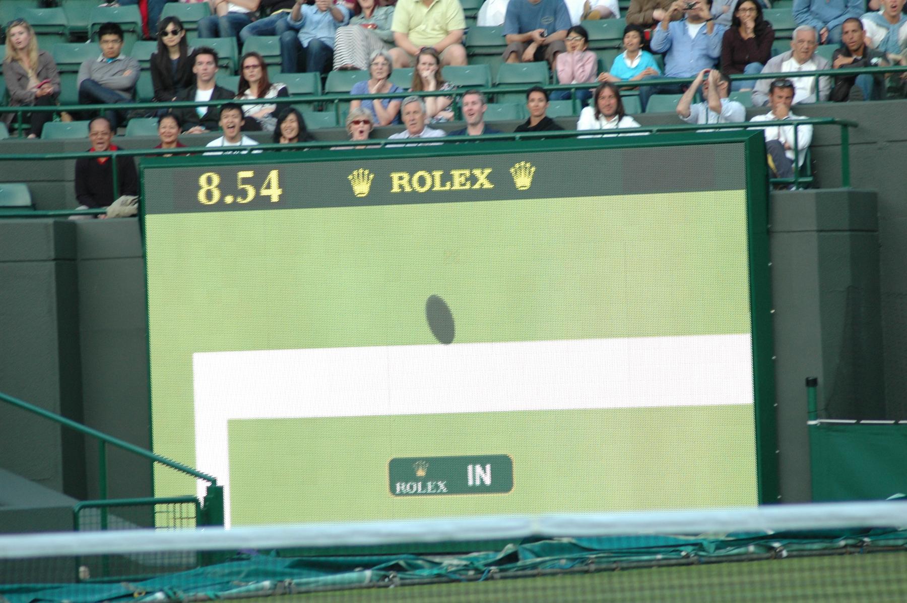 a man in a green shirt is playing tennis - File:The decision of In or Out with the help of Technolog