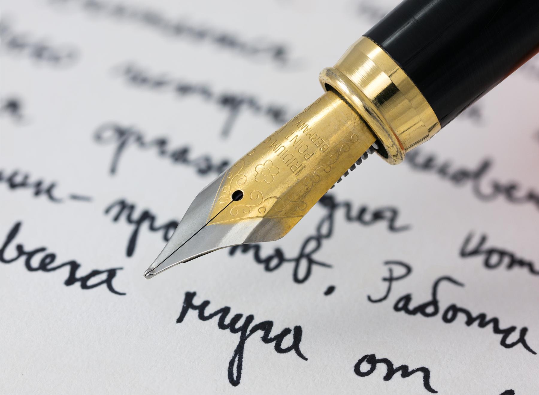 a pen and a pen on a piece of paper - File:Fountain pen writing (literacy).jpg