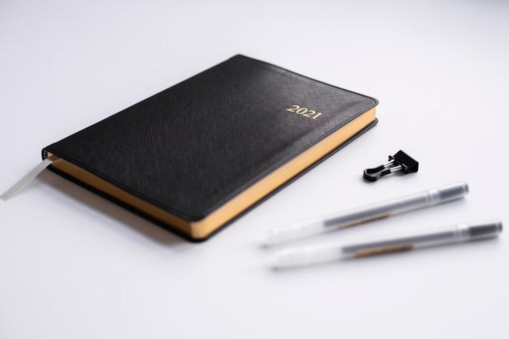 close up 2021 stationary - a black notebook with a pen and a pen