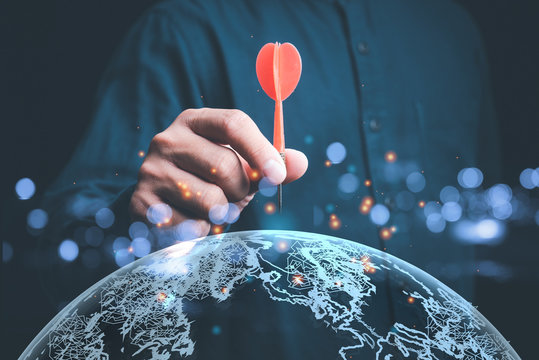 Businessman holding red darts with virtual screen  globe..targeting the business concept